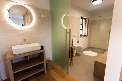 a bathroom with a sink and a mirror at Vinoteka Brda in Šmartno