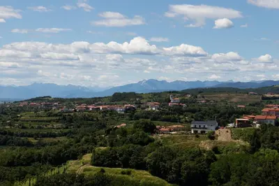 a town on a hill with mountains in the background at Vinoteka Brda in Šmartno