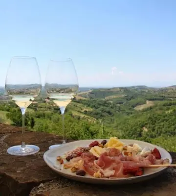 a plate of food and two glasses of wine at Vinoteka Brda in Šmartno