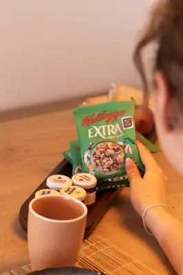 a woman holding a cup of coffee and a box of expired expired expired expired food at Vinoteka Brda in Šmartno