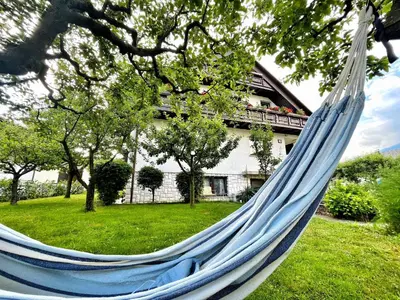 a blue hammock in a yard with a house at Papas Apartment in Lesce