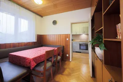 a dining room with a table and chairs and a kitchen at Papas Apartment in Lesce