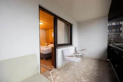 a room with two chairs and a table and a bed at Papas Apartment in Lesce