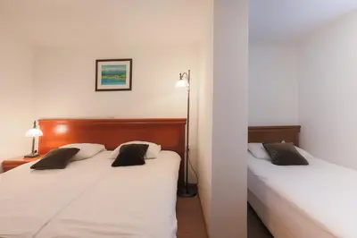 a bedroom with two beds and a lamp at Papas Apartment in Lesce