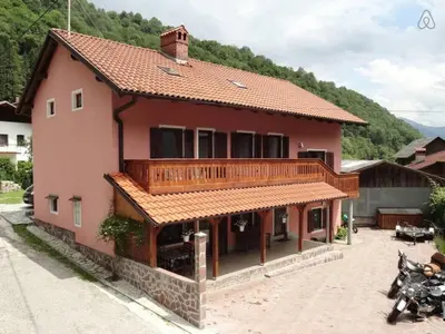 a large red house with a balcony on a street at House Maharac with 3 apartments till 15 persons in Kamno