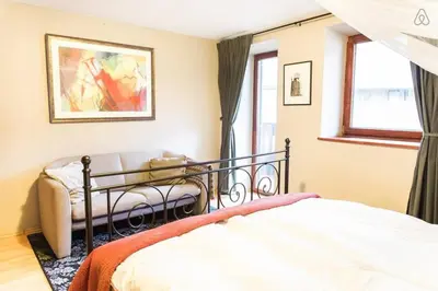 a bedroom with a bed and a couch and a window at House Maharac with 3 apartments till 15 persons in Kamno