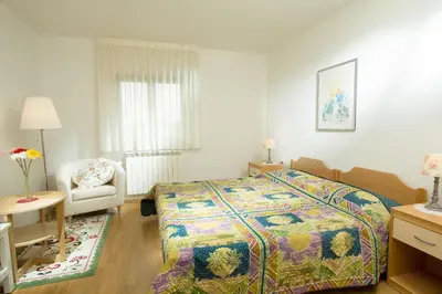 a bedroom with a bed and a chair in it at Valentina Guest House at Pintar Wine Estate in Kojsko