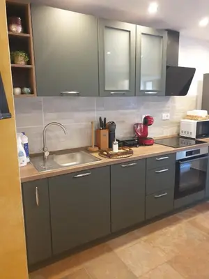 a kitchen with gray cabinets and a sink at Apartma na klancu in Kobarid