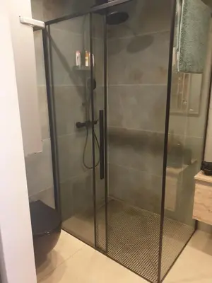 a shower with a glass door in a bathroom at Apartma na klancu in Kobarid