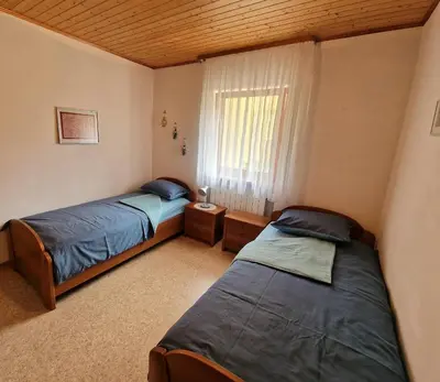 a bedroom with two beds and a window with at Merlin in Renče