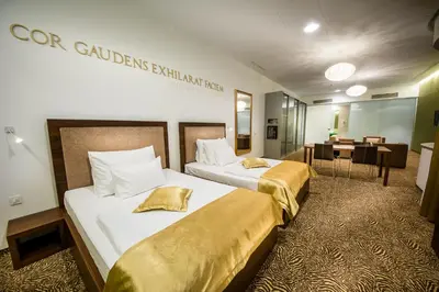 a hotel room with two beds and a dining room at Rimske Terme Resort - Hotel Rimski dvor in Rimske Toplice