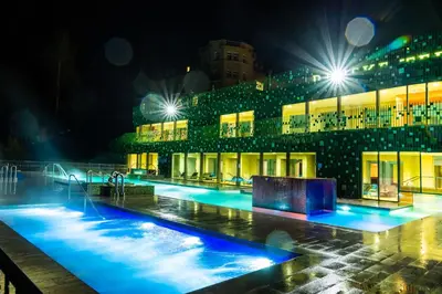 a building with a pool at night with blue lights at Rimske Terme Resort - Hotel Rimski dvor in Rimske Toplice