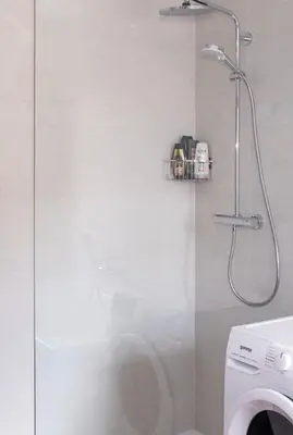 a shower in a bathroom with a washing machine at Riverview Lodge in Bohinj