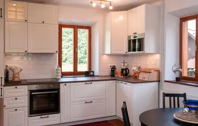 a kitchen with white cabinets and a table at Riverview Lodge in Bohinj