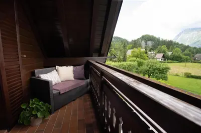 a balcony with a chair and a view of the mountains at View apartment Lenart in Bohinj