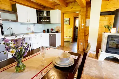 a kitchen with a table with a vase of flowers on it at Apartma Smithy (Kovačnica) in Laško