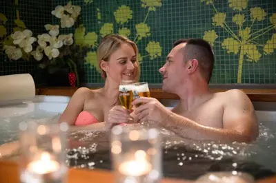 a man and woman sitting in a bathtub drinking champagne at Apartma Smithy (Kovačnica) in Laško
