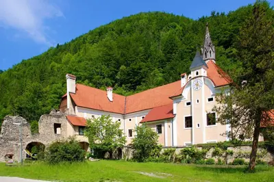 a large building with a clock tower on a hill at Apartma Smithy (Kovačnica) in Laško