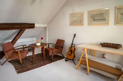 a room with a table and chairs and a guitar at Art House Radovljica in Radovljica