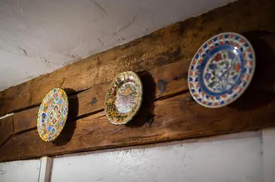 a group of plates on a wooden wall at Art House Radovljica in Radovljica