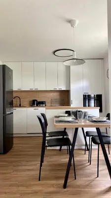 a kitchen with a table and chairs and a kitchen with white cabinets at Lanima in Bled