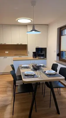 a kitchen with a wooden table with chairs and a dining room at Lanima in Bled