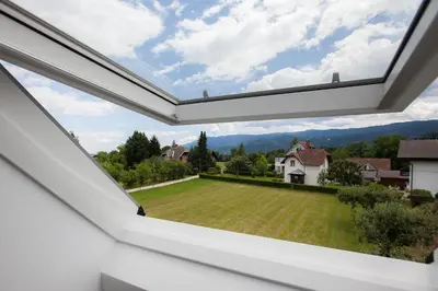 an open window in a house with a green yard at Design & Wine Vila Special Bled in Bled