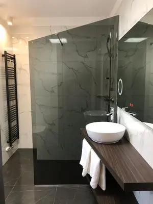 a bathroom with a sink and a glass shower at Design & Wine Vila Special Bled in Bled