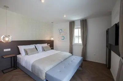 a bedroom with a large bed and a television at Design & Wine Vila Special Bled in Bled