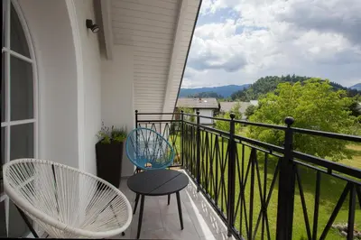 a balcony with two chairs and a view at Design & Wine Vila Special Bled in Bled