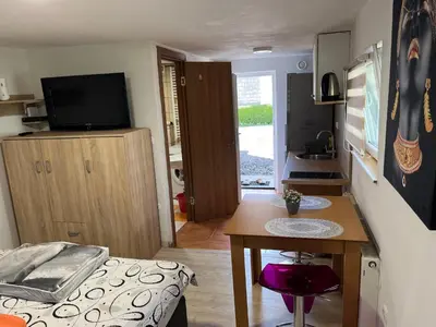 a small room with a bed and a table and a television at Apartments Malivojevič in Žirovnica