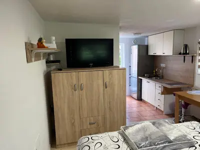 a kitchen with a tv on top of a wooden cabinet at Apartments Malivojevič in Žirovnica