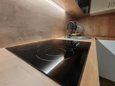 a kitchen with a sink and a black counter top at Apartments Malivojevič in Žirovnica