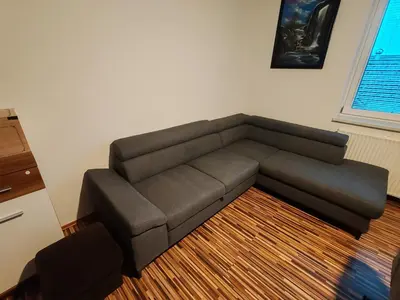 a brown couch in a living room next to a window at Apartments Malivojevič in Žirovnica