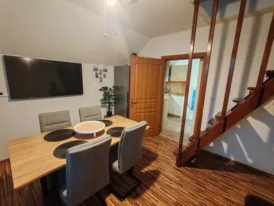 a dining room table with chairs and a flat screen tv at Apartments Malivojevič in Žirovnica