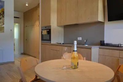 a bottle of wine sitting on a table in a kitchen at APARTMA VODNIK in Bohinj