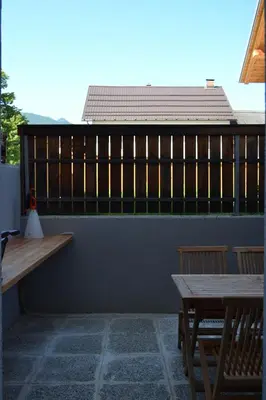 a patio with two wooden benches and a table at APARTMA VODNIK in Bohinj
