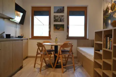 a kitchen and dining room with a table and chairs at APARTMA VODNIK in Bohinj