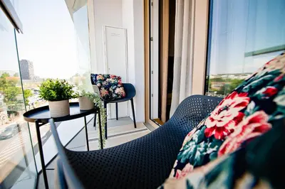 a balcony with two chairs and a table and a window at Apartma 2+2 v mestu Ljubljana (V325) in Ljubljana