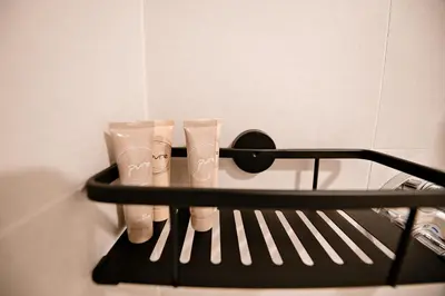 a black rack with four pairs of shoes on it at Apartma 2+2 v mestu Ljubljana (V325) in Ljubljana