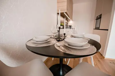 a black dining room table with plates and glasses on it at Apartma 2+2 v mestu Ljubljana (V325) in Ljubljana