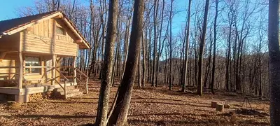 a wooden cabin in the middle of the woods at Cowboy House at Ranch Lambergar in Gabrovka