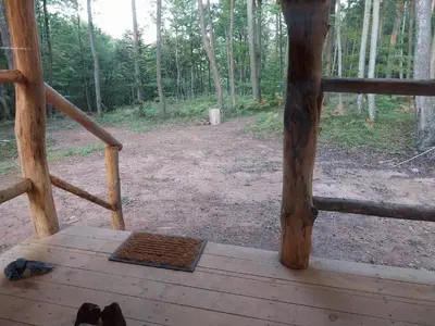 a view from the porch of a wooden cabin with a wooden floor at Cowboy House at Ranch Lambergar in Gabrovka