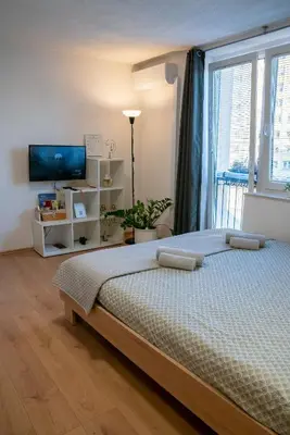 a bedroom with a bed and a large window at Small but cozy apartment in Maribor