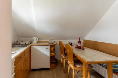 a kitchen with a wooden table and a sink at Apartment Vidmar in Bohinj
