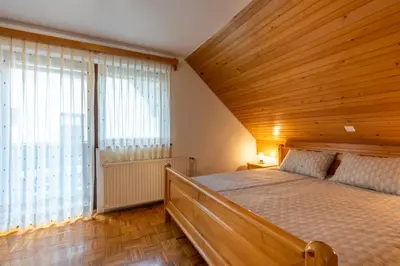 a bedroom with a bed and a large window at Apartment Vidmar in Bohinj