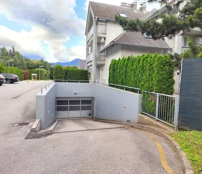 a white house with a garage in the street at Alpine Nest in Bled