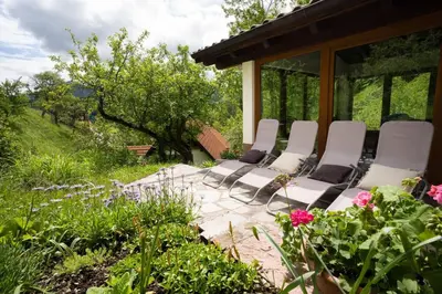 a group of white chairs sitting on a patio at At Peskar's a charming countryside house in Podbrdo