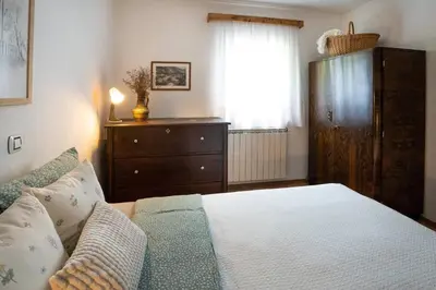 a bedroom with a bed and a dresser and a window at At Peskar's a charming countryside house in Podbrdo