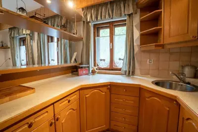 a kitchen with wooden cabinets and a sink and a window at At Peskar's a charming countryside house in Podbrdo